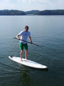 Standing unsteadily on a stand-up paddle board